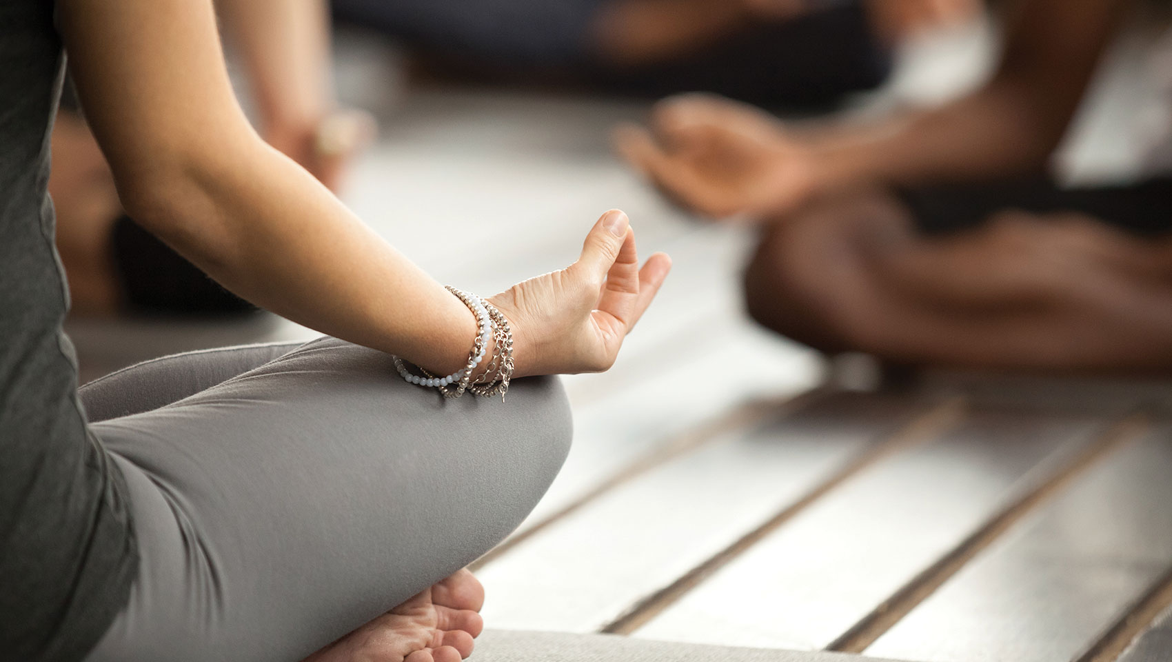 person sitting legs crossed with yoga hands