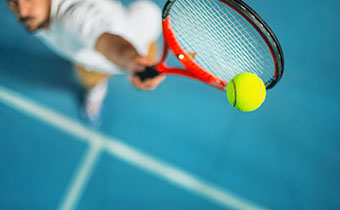 Person hitting tennis ball with racquet